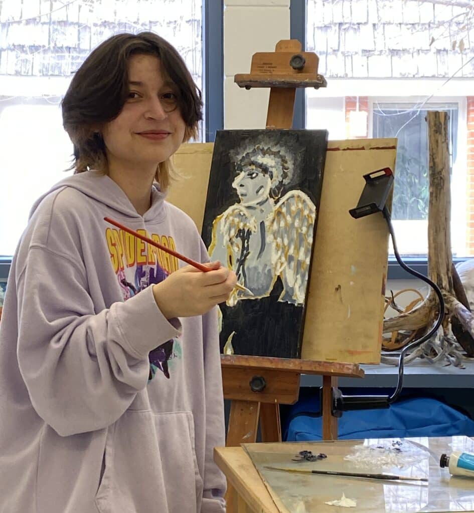 Atlas holding paintbrush in front of canvas