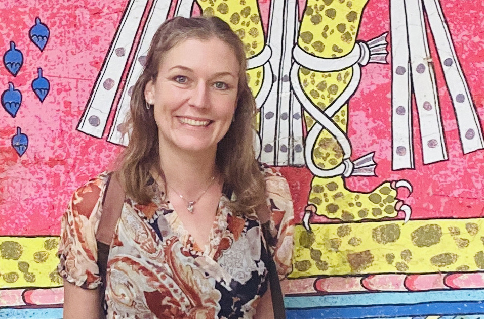 Photo of Annie Bergen in front of colourful mural