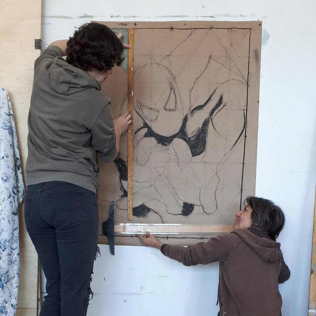 Lara and Deborah hanging a large piece of art