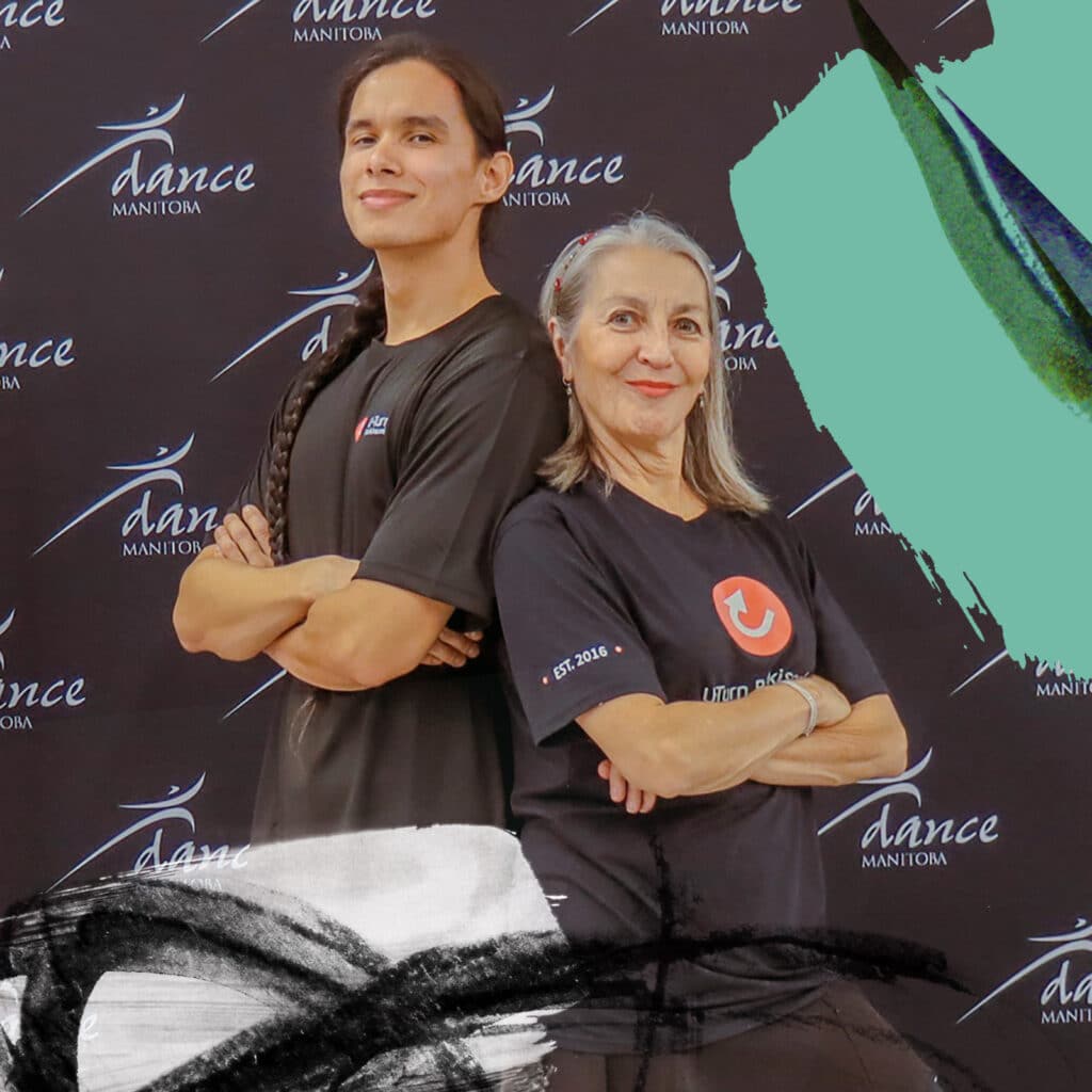 A man with long hair leans back to back against a woman with long greyish hair